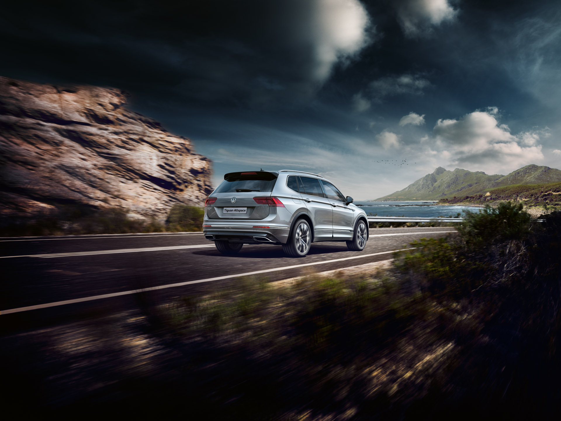 Tiguan Allspace speeding down a highway next to the ocean